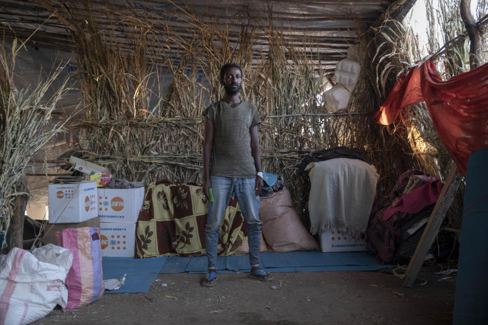 Samir Beyen, 26, a survivor from Mai-Kadra, Ethiopia, stands inside his shelter at Umm Rakouba refugee camp in Qadarif, eastern Sudan, Nov. 25, 2020. Witnesses say hundreds of civilians were slaughtered in Mai-Kadra, but they disagree about who killed whom. "It was like the end of the world," recalled Beyen, a mechanic, who said he was stopped and asked if he was Tigrayan, then beaten and robbed. He said he saw people being slaughtered with knives, and dozens of rotting corpses. "We could not bury them because the soldiers were near," he said. Some witnesses said Ethiopian federal and Amhara regional troops attacked Tigrayans, while others say it was Tigrayan forces and their allies who targeted Amhara. (AP Photo/Nariman El-Mofty)