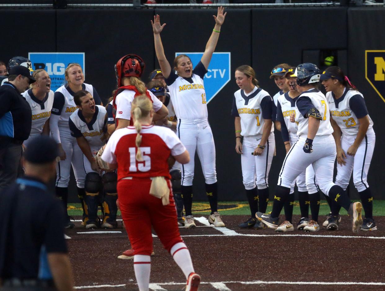 Michigan’s Maddie Erickson (7) is greeted by her teammates at home plate after hitting a home run during the Big Ten softball tournament Friday, May 10, 2024 in Iowa City, Iowa.