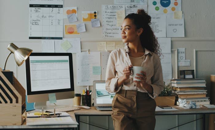 young woman drinking coffee at her desk