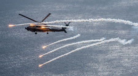 A U.S. Navy MH-60R Sea Hawk helicopter from the "Blue Hawks" of Helicopter Maritime Strike Squadron 78 fires chaff flares during a training exercise near the aircraft carrier USS Carl Vinson (CVN 70) in the Philippine Sea April 24, 2017. U.S. Navy/Mass Communication Specialist 2nd Class Sean M. Castellano/Handout via REUTERS