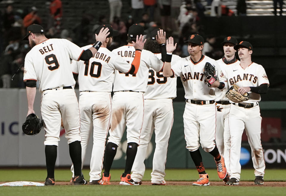 SAN FRANCISCO, CALIFORNIA - MAY 10: Mauricio Dubon #1 of the San Francisco Giants front, right, and his teammates celebrate defeating the Texas Rangers 3-1 at Oracle Park on May 10, 2021 in San Francisco, California. (Photo by Thearon W. Henderson/Getty Images)