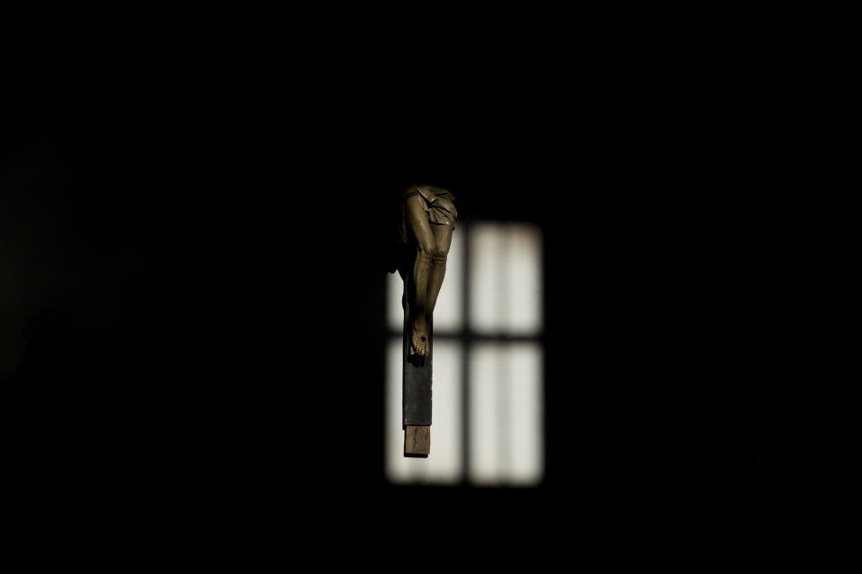 A crucifix is partially illuminated by a shaft of sunlight from one of the windows in the 12th century Romanesque church of Tardobispo, in the Zamora province of Spain, on Sunday, Nov. 28, 2021. According to the Sociological Research Center, a public institute, 62% of Spaniards define themselves as Catholics, down from 85% in 2000 and 98% in 1975. Only about one-third of those Catholics say they’re actively practicing the faith. (AP Photo/Manu Brabo)