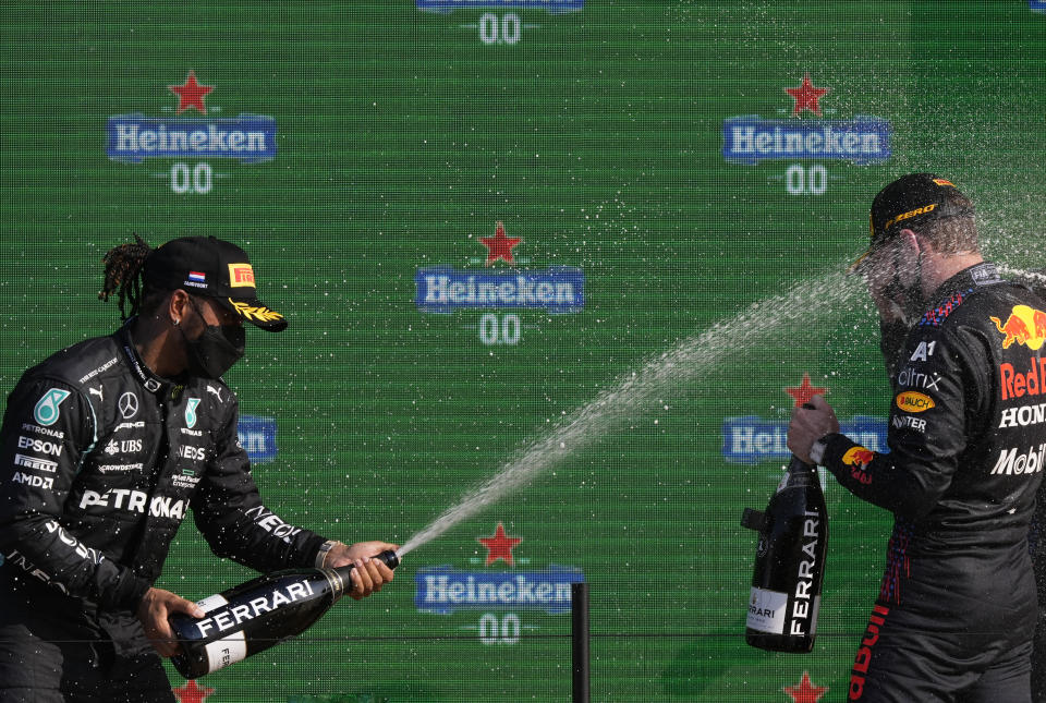 Second placed Mercedes driver Lewis Hamilton of Britain, left, sprays champagne on a race winner Red Bull driver Max Verstappen of the Netherlands after the Formula One Dutch Grand Prix, at the Zandvoort racetrack, Netherlands, Sunday, Sept. 5, 2021. (AP Photo/Peter Dejong)