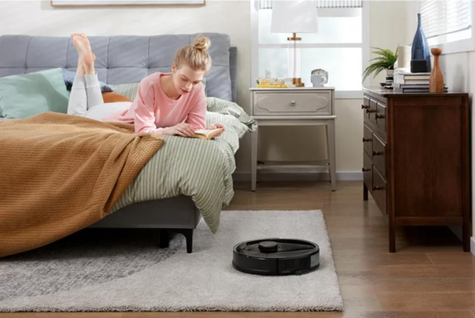 a robot vacuum cleaner on the carpet of a girl's bedroom