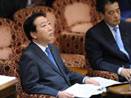 Japan's Prime Minister Yoshihiko Noda (left) and Deputy Prime Minister Katsuya Okada attend an upper house special committee session at the parliament in Tokyo. A bill to double Japan's sales tax and partially plug its gaping debt hole cleared its final parliamentary hurdle in a triumph for the prime minister that could ultimately also cost him his job
