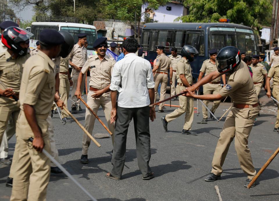 Image: Indian policemen beat a lower caste Dalit protestor during a nationwide strike in Ahmadabad, India. (Ajit Solanki / AP file)