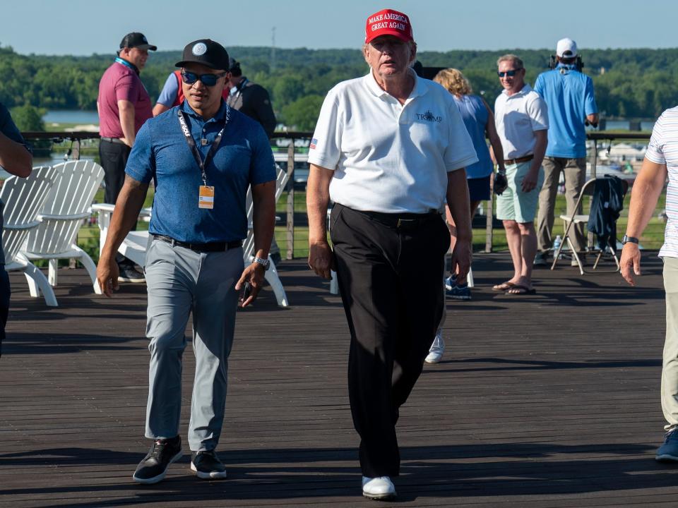 Walt Nauta, left, walks with Former President Donald Trump during the first round of the LIV Golf at Trump National Golf Club.