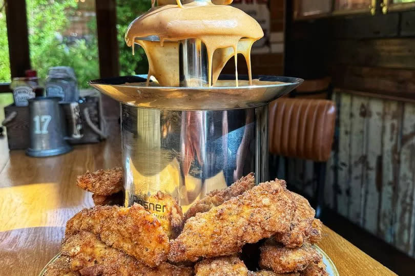 PIC FROM KENNEDY NEWS/DOLECTIVE (PICTURED: THE FRIED CHICKEN FOUNTAIN THE LEOPARD PUB IN NANTWICH, CHESHIRE, IS LAUNCHING SOON) A pub is sending fried chicken fans into meltdown by launching a giant GRAVY FOUNTAIN with a monster portion of 30 chicken tenders to dip into it. The Leopard in Nantwich, Cheshire, has gone viral after revealing they're set to serve a litre of home-made gravy in a 15-inch tall fountain for hungry punters to dip fried chicken and fries into. Videos of the Fried Chicken Fountain show curtains of the condiment flowing from the heated spring, while a diner smothers the boozer's 'Leopard Fried Chicken' in it. DISCLAIMER: While Kennedy News and Media uses its best endeavours to establish the copyright and authenticity of all pictures supplied, it accepts no liability for any damage, loss or legal action caused by the use of images supplied and the publication of images is solely at your discretion. SEE KENNEDY NEWS COPY - 0161 697 4266 -Credit:Kennedy News/Dolective