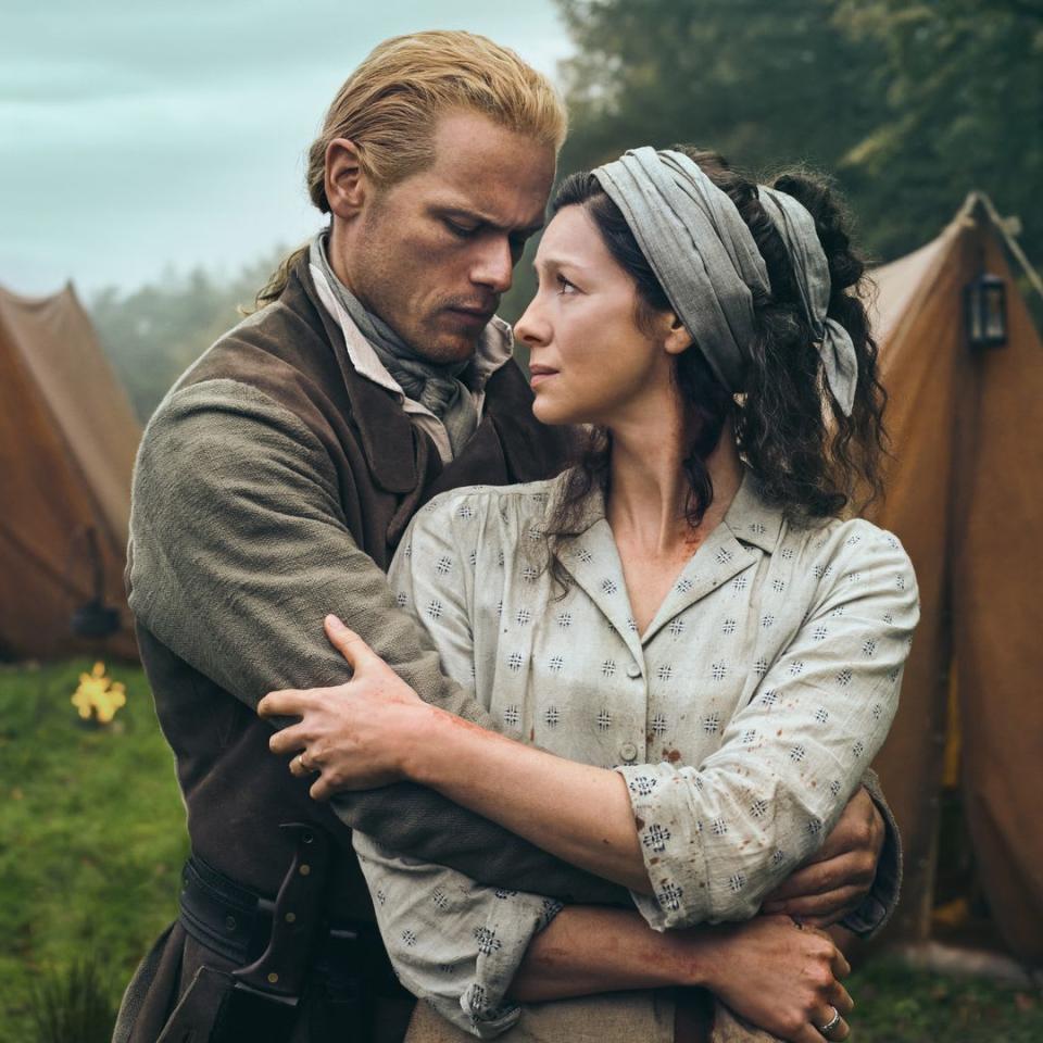 Sam Heughan and Caitriona Balfe embrace and stare at each other as their characters in Outlander Season Seven