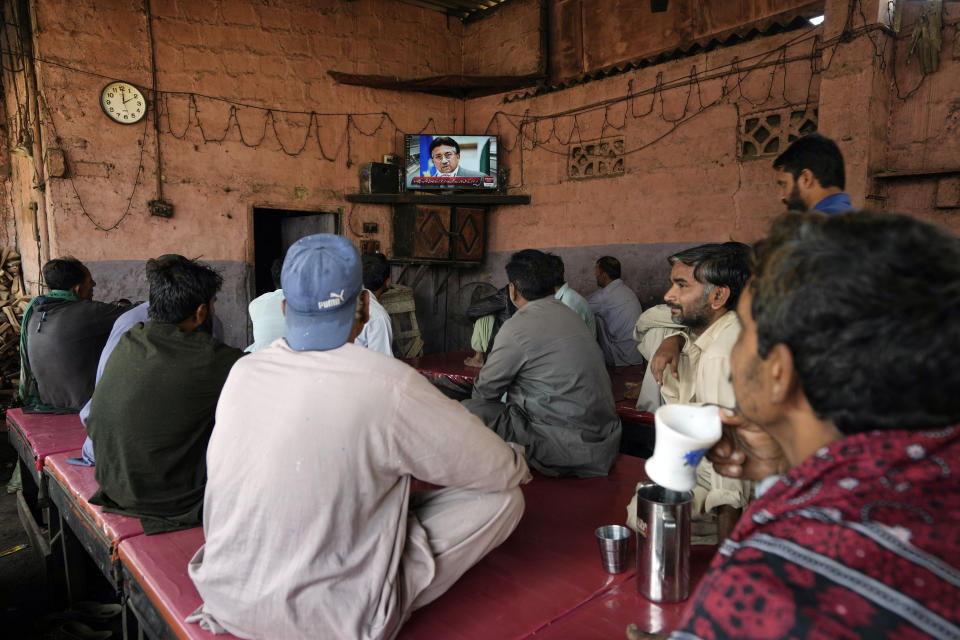 People watch a TV news report about the death of former Pakistani President Gen. Pervez Musharraf at a coffee shop in Karachi, Pakistan, Sunday, Feb. 5, 2023. Musharraf, who seized power in a bloodless coup and later led a reluctant Pakistan into aiding the U.S. war in Afghanistan against the Taliban, has died, officials said Sunday. He was 79. (AP Photo/Fareed Khan)