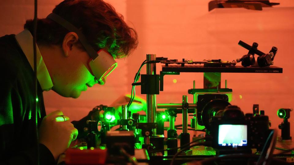 A researcher at HoloMem working with lasers