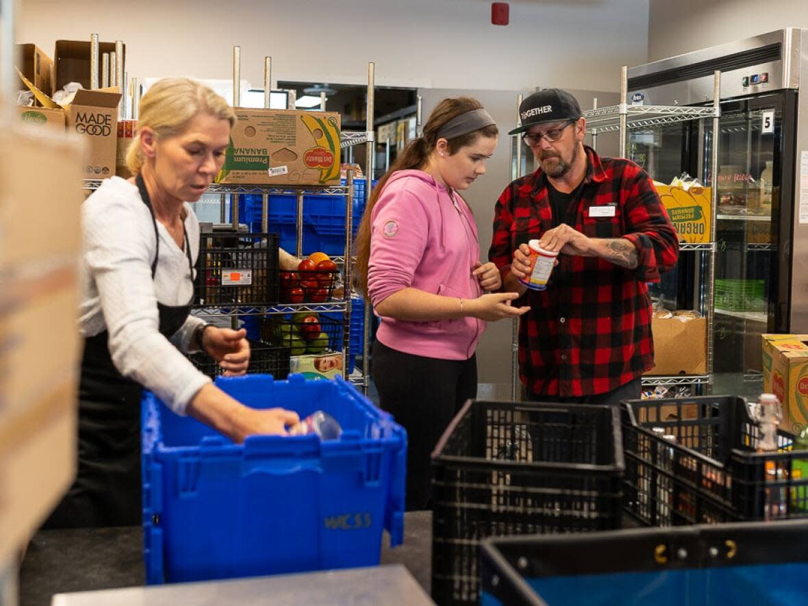 Volunteers at the food bank run by Whistler Community Services Society are pictured next to Fraser Carey, right, food security co-ordinator. The food bank has seen a dramatic increase in visits since the pandemic started.  (Mark Halliday/Moonrider Productions - image credit)