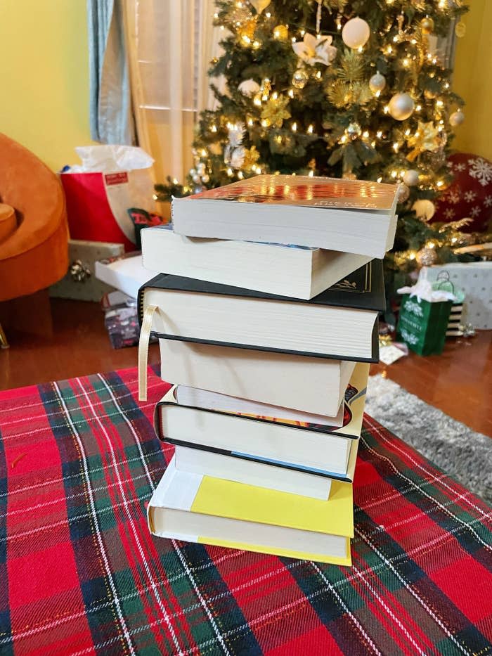 A stack of books are on a coffee table