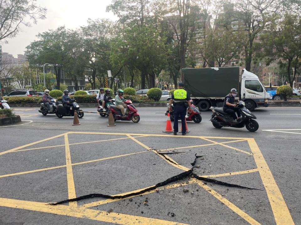 高雄市三民區民族一路與寶鼎街口的機慢車道，今天下午路面突然爆裂，幸未波及路過人車。（圖：三民二分局提供）