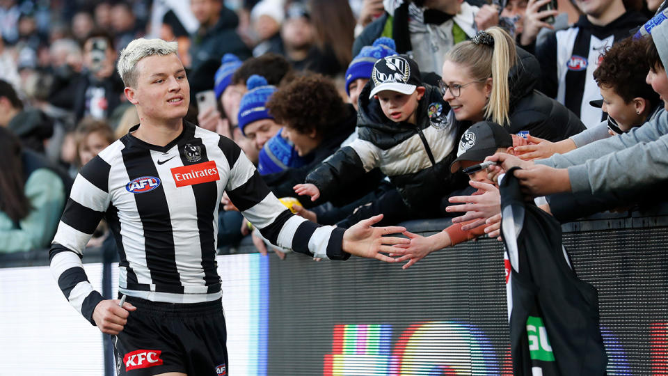 Jack Ginnivan hi-fives Collingwood fans after the team's win over Port Adelaide.