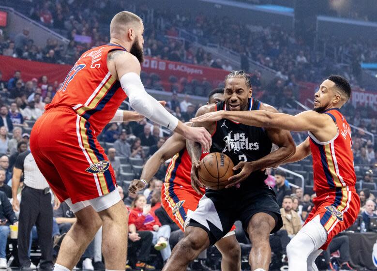 LOS ANGELES, CA - FEBRUARY 7, 2024: LA Clippers forward Kawhi Leonard (2) is double teamed by New Orleans Pelicans center Jonas Valanciunas (17) and New Orleans Pelicans guard CJ McCollum (3) as he drives to the basket in the first half at Crypto.com Arena on February 7, 2024 in Los Angeles, California.(Gina Ferazzi / Los Angeles Times)