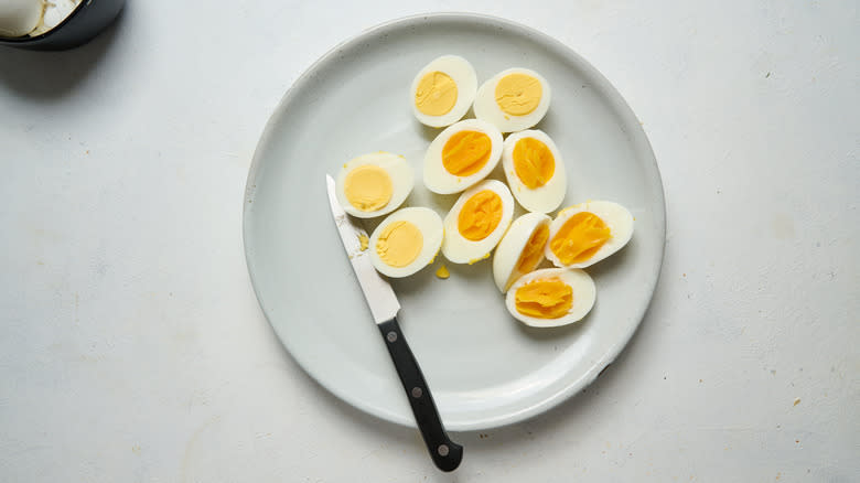hard boiled egg halves on plate with knife