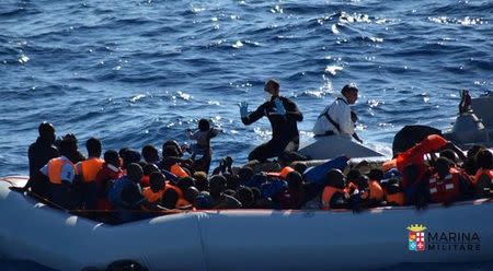 Migrants sit in their rubber dinghy during a rescue operation by Italian navy ship Borsini (unseen) off the coast of Sicily, Italy, in this handout picture courtesy of the Italian Marina Militare released July 19, 2016. Marina Militare/Handout via REUTERS