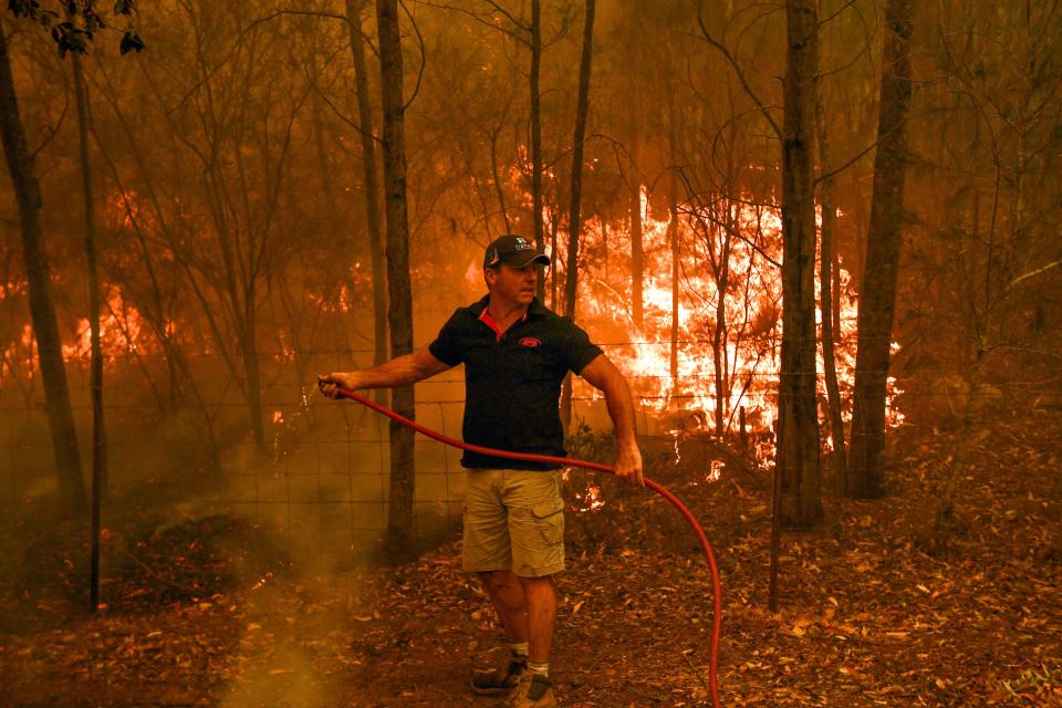 Firefighters hose down during a bushfire in Werombi, 50km southwest of Sydney.