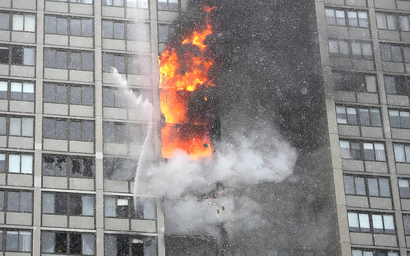 Flames leap skyward out of the Harper Square cooperative residential building in the Kenwood neighborhood of Chicago on Jan. 25. <em>Associated Press/Charles Rex Arbogast</em>