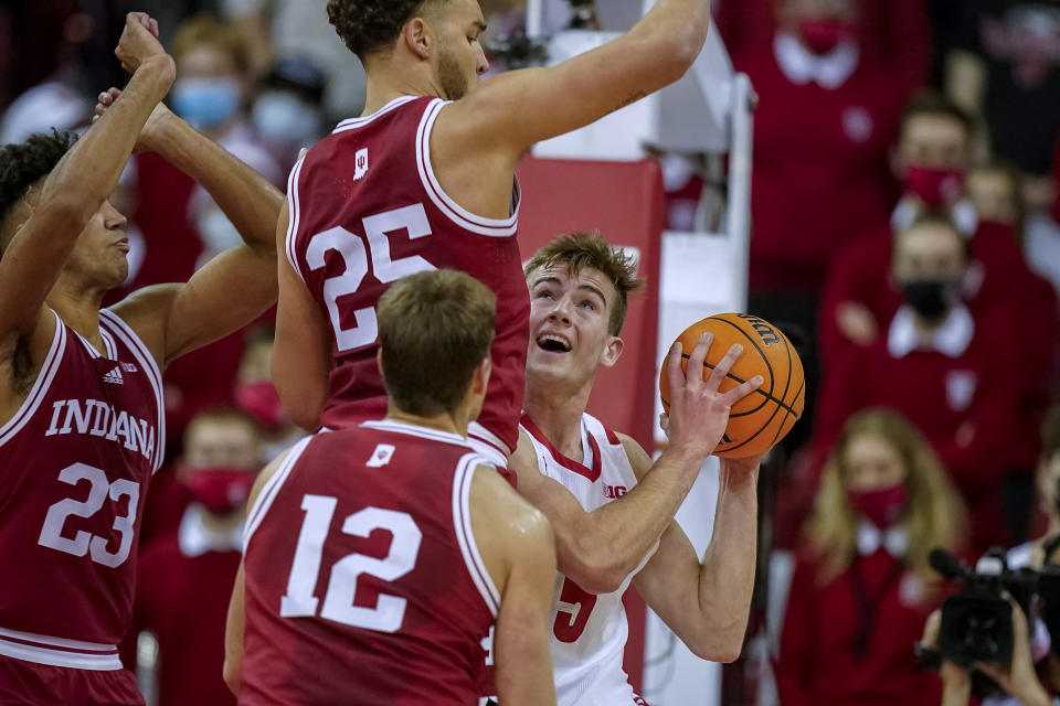 Wisconsin's Tyler Wahl (5) is defended by Indiana's Trayce Jackson-Davis (23), Race Thompson (25) and Miller Kopp (12) during the first half of an NCAA college basketball game Wednesday, Dec. 8, 2021, in Madison, Wis. (AP Photo/Andy Manis)