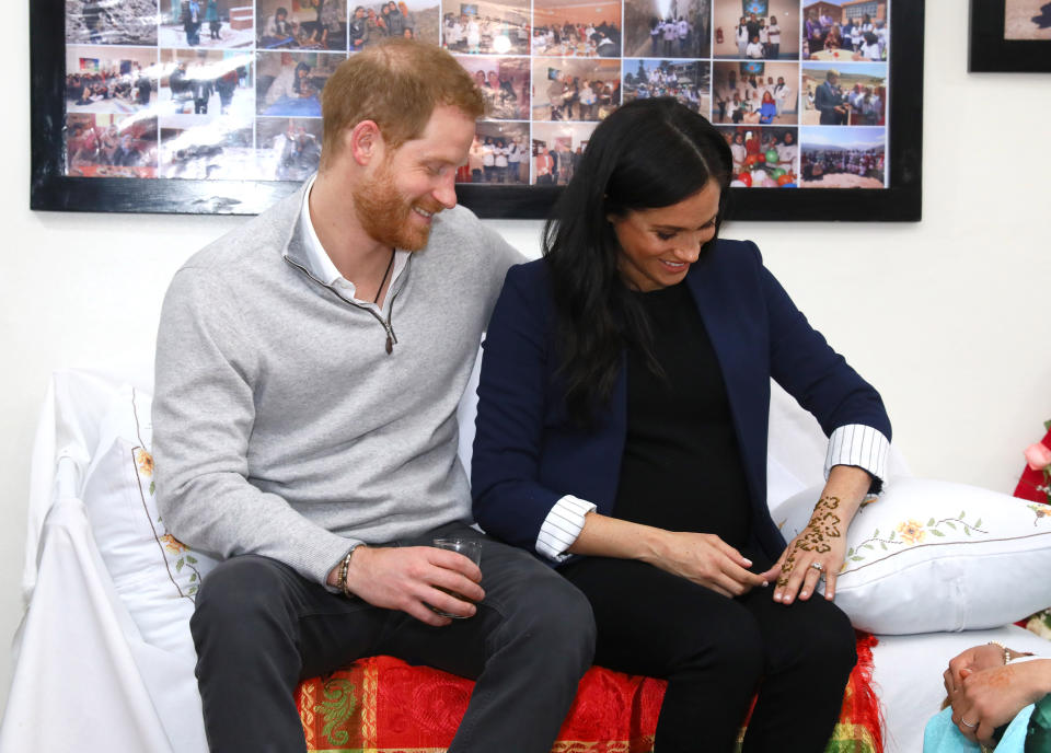 With Harry watching, Meghan had a floral pattern painted on her left hand and wrist.