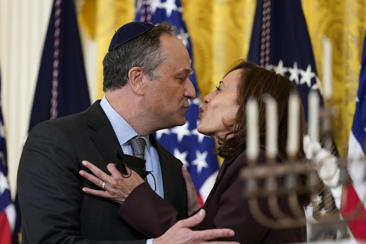 Vice President Kamala Harris, at right, and second gentleman Doug Emhoff kiss during an event in the East Room of the White House to light the menorah to celebrate Hanukkah in 2021. 