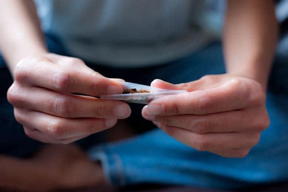 young woman makes cigarette...