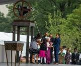 US President Barack Obama and Ruth Odom Bonner (purple) , along with her family and US First Lady Michelle Obama (L), ring a bell to mark the opening of the Smithsonian National Museum of African American History and Culture, on September 24, 2016