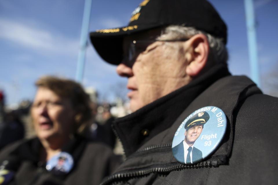 Lowell Dahl wears a button honoring Flight 93 Capt. Jason Dahl during a commissioning ceremony for the USS Somerset (LPD 25) Saturday Mar. 1, 2014, in Philadelphia. The USS Somerset is the ninth San Antonio-class amphibious transport dock and the third of three ships named in honor of those victims and first responders of the attacks on the World Trade Center and the Pentagon. The ship is named for the county where Flight 93 crashed after being hijacked on Sept. 11, 2001. (AP Photo/ Joseph Kaczmarek)