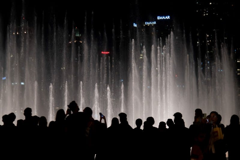 People make photographs and record videos on their phones of a fountain show at the Dubai Fountains on Dec. 21, 2023. <span class="copyright">Kabir Jhangiani—NurPhoto/Getty Images</span>