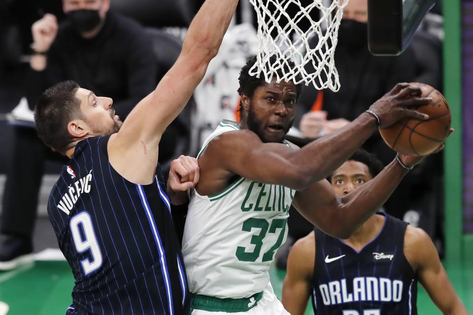 Boston Celtics' Semi Ojeleye (37) tries to shoot against Orlando Magic's Nikola Vucevic (9) during the first half on an NBA basketball game, Sunday, March 21, 2021, in Boston. (AP Photo/Michael Dwyer)