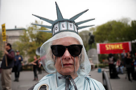 A woman stands dressed as the Statue of Liberty during a May Day protest in New York, U.S. May 1, 2017. REUTERS/Mike Segar