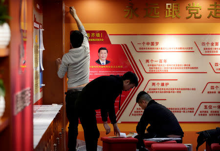 FILE PHOTO: Workers decorate the party activity room next to a portrait of Chinese president Xi Jinping at Tidal Star Group headquarters in Beijing, China, February 25, 2019. REUTERS/Jason Lee/File Photo