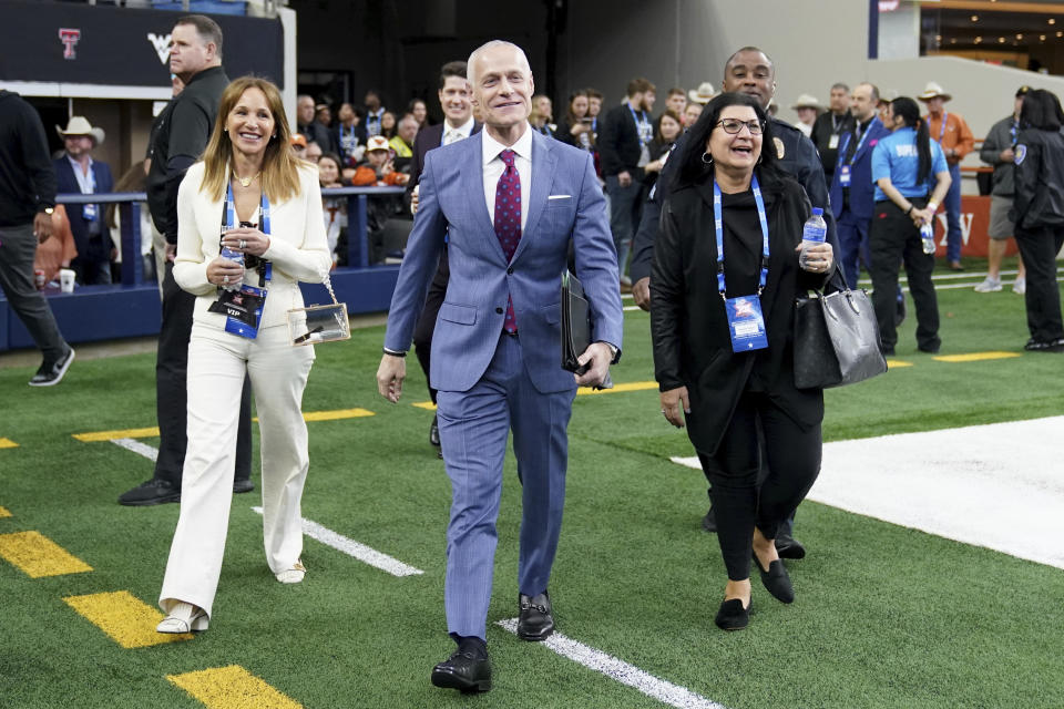 Big 12 Commissioner Brett Yormark, center, walks onto the field in the first half of the Big 12 Conference championship NCAA college football game between Oklahoma State and Texas in Arlington, Texas, Saturday, Dec. 2, 2023. (AP Photo/Tony Gutierrez)