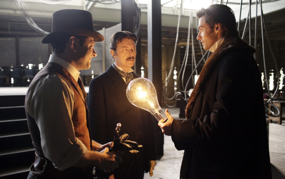 Andy Serkis, David Bowie, and Hugh Jackman in a still from The Prestige. (Warner Bros.)