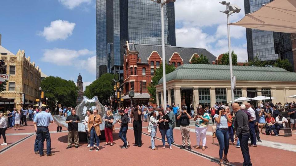 People in the Sundance Square plaza look up at the eclipse on Monday, April 8, 2024, in Fort Worth. Harrison Mantas/hmantas@star-telegram.com