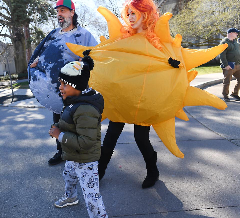 Melanie Newton and Greg Newton, wearing costumes of the sun and moon respectively, dazzled children and adults alike April 7 outside the Rochester Museum & Science Center.