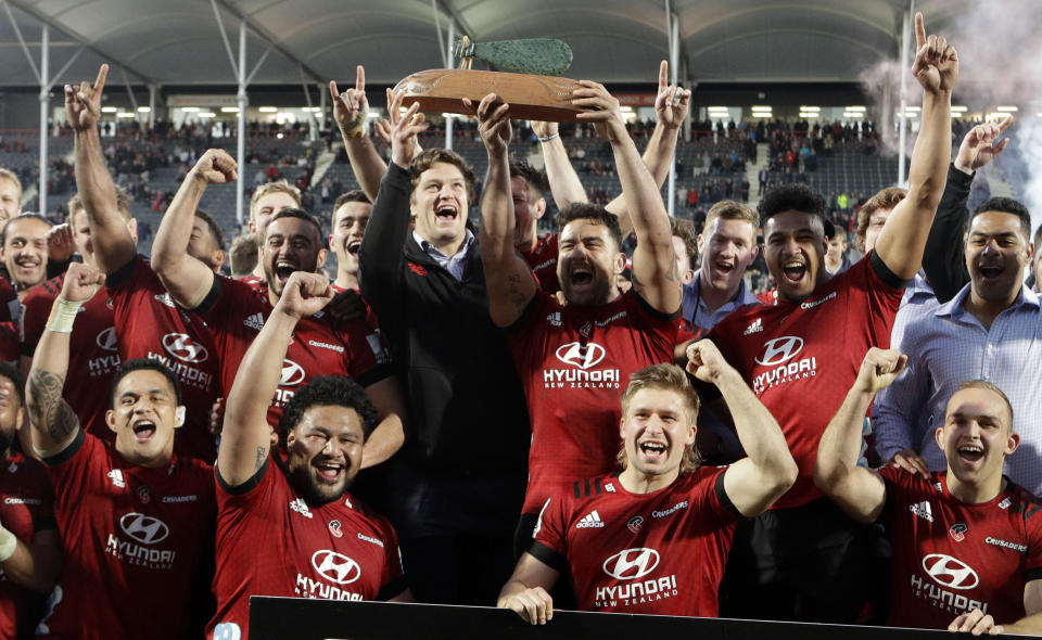 Crusaders Codie Taylor and injured teammate Scott Barrett hold the Super Rugby Aotearoa trophy aloft after defeating the Highlanders in Christchurch, New Zealand, Sunday, Aug. 9, 2020. (AP Photo/Mark Baker)