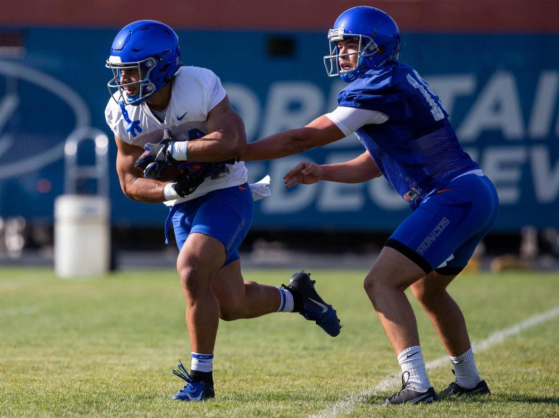 Boise State quarterback Hank Bachmeier hands off the football to running back George Holani during drills on the first day of fall camp, Wednesday, Aug. 3, 2022.