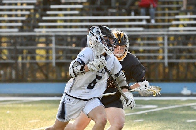 Wayne Valley's Ryan Schmitz (6) is guarded closely by a Ramsey defender during a boys lacrosse game on April 13, 2023.