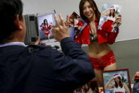 A man takes pictures of ring announcer Fuka Kakimoto of Stardom, a Japanese female professional wrestling promotion, after a show at Korakuen Hall in Tokyo, Japan, December 23, 2015. REUTERS/Thomas Peter