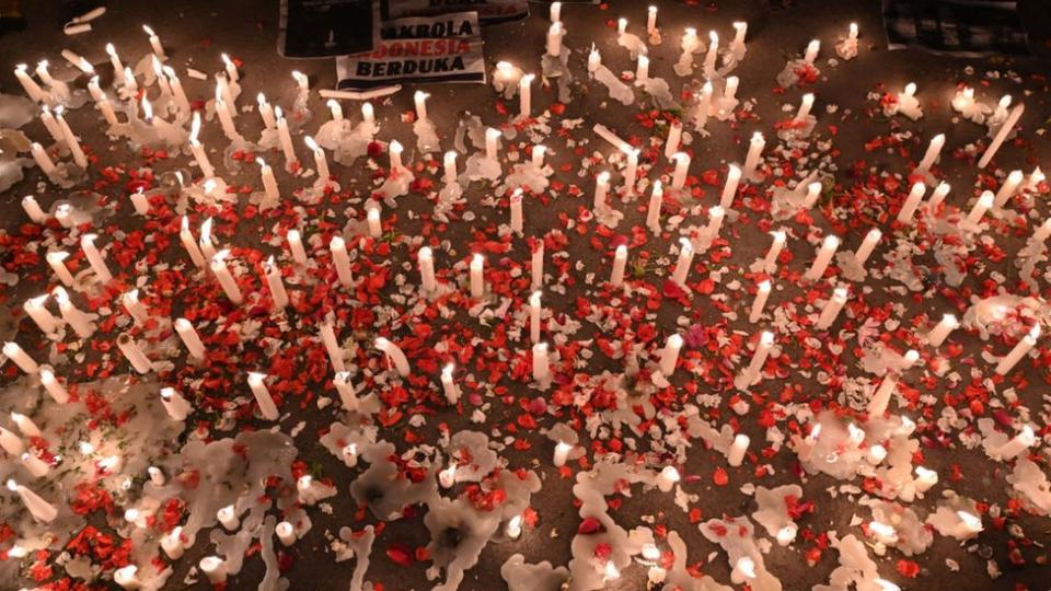 Un monumento con velas y flores en honor a las víctimas de la estampida.