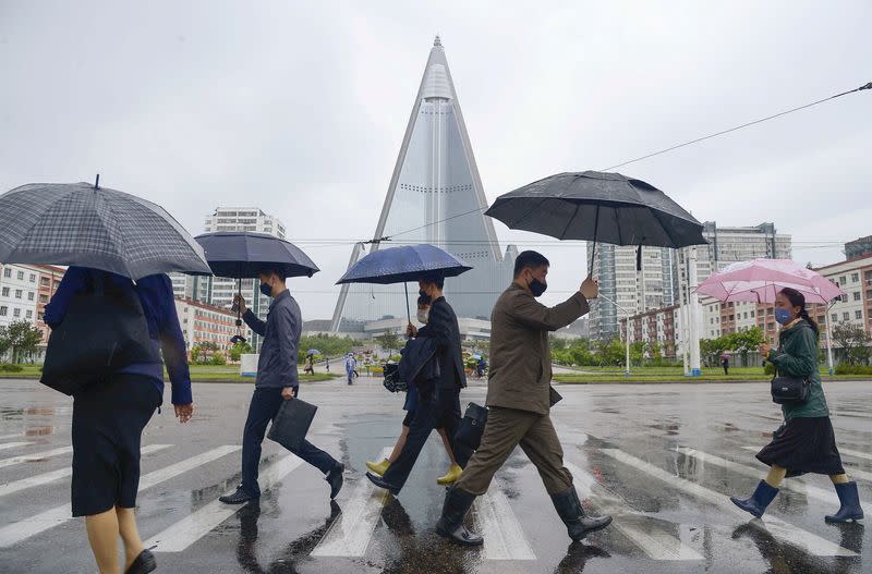 FILE PHOTO: People wearing protective face masks walk amid concerns over the new coronavirus disease (COVID-19) in Pyongyang, North Korea