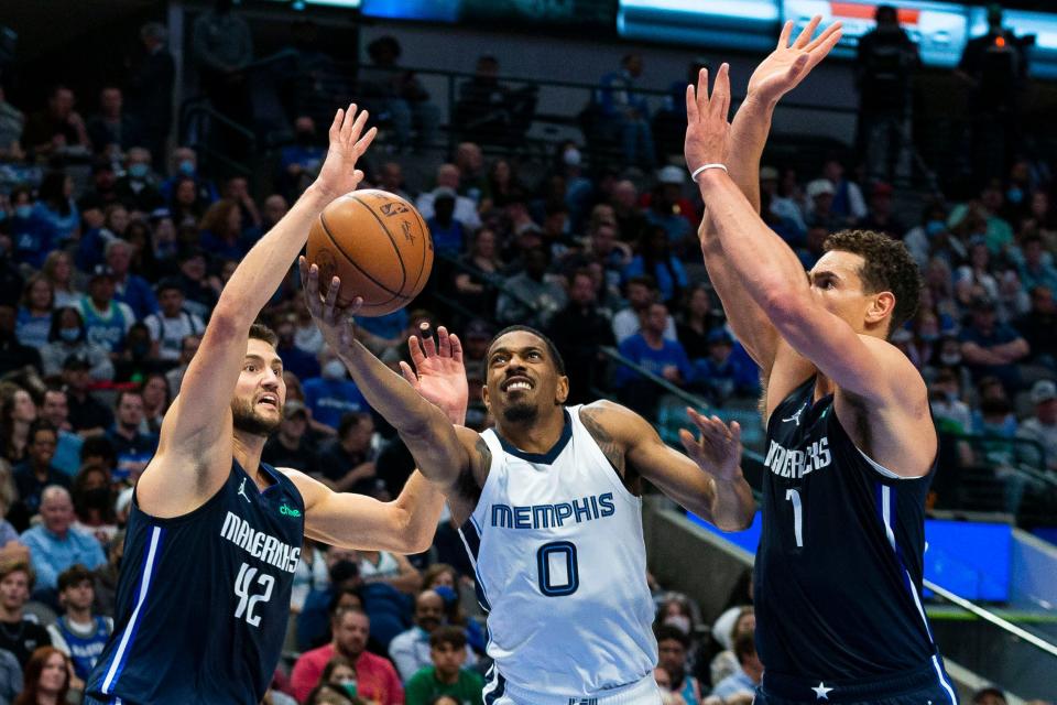 Memphis Grizzlies guard De'Anthony Melton (0) makes a move toward the basket as Dallas Mavericks forward Maxi Kleber (42) and center Dwight Powell (7) defend during the first half of an NBA basketball game, Saturday, Dec. 4, 2021, in Dallas. (AP Photo/Sam Hodde)