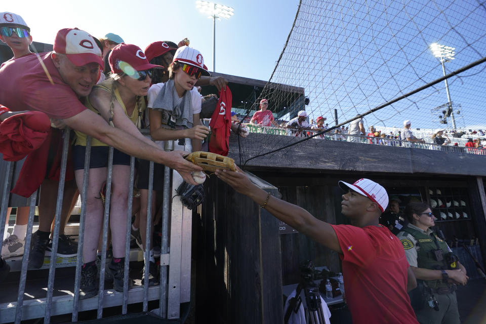 Cincinnati Reds' Hunter Greene signs items for fans before a baseball game against the Chicago Cubs at the Field of Dreams movie site, Thursday, Aug. 11, 2022, in Dyersville, Iowa. (AP Photo/Charlie Neibergall)