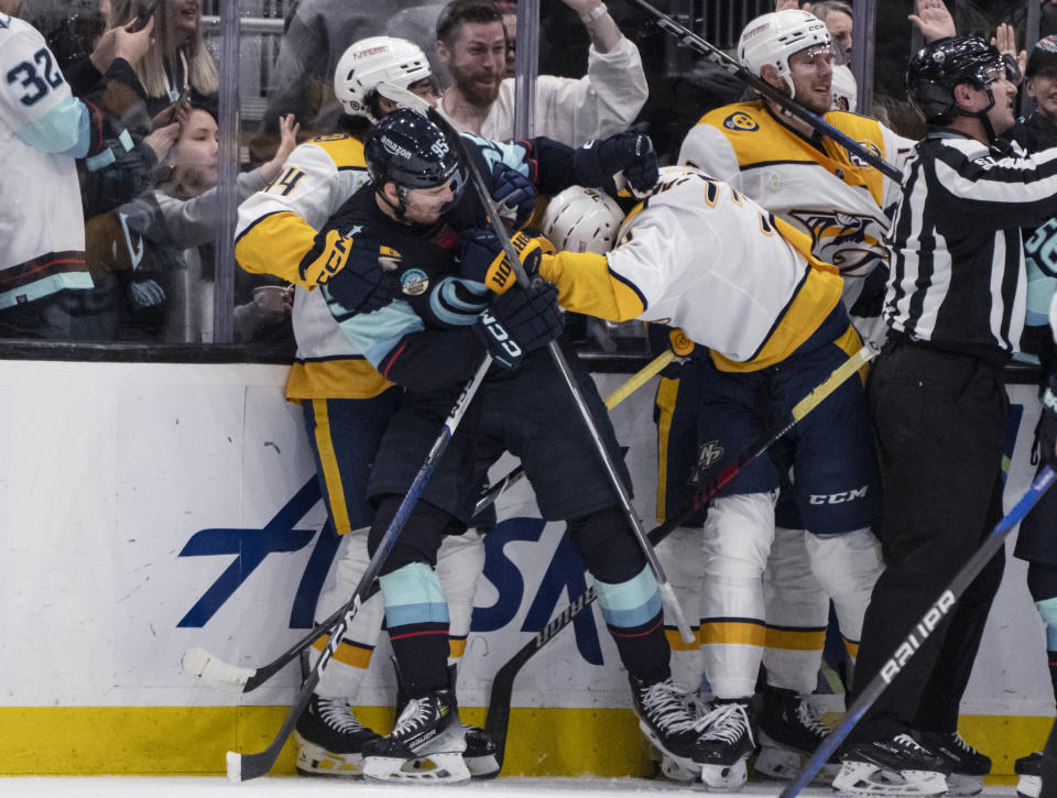 Seattle Kraken forward Andre Burakovsky, second from left, scuffles with Nashville Predators forward Kiefer Sherwood, left, and forward Cole Smith during the second period of an NHL hockey game Saturday, March 16, 2024, in Seattle. (AP Photo/Stephen Brashear)