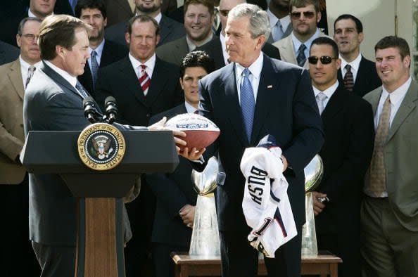 WASHINGTON - APRIL 13:  New England Patriots head coach Bill Belichick (L) presents U.S. President George W. Bush (R) with a football during a Rose Garden event to honor the Super Bowl champions at the White House April 13, 2005 in Washington, DC. The Patriots have won three Championships in the last four years.  (Photo by Alex Wong/Getty Images)