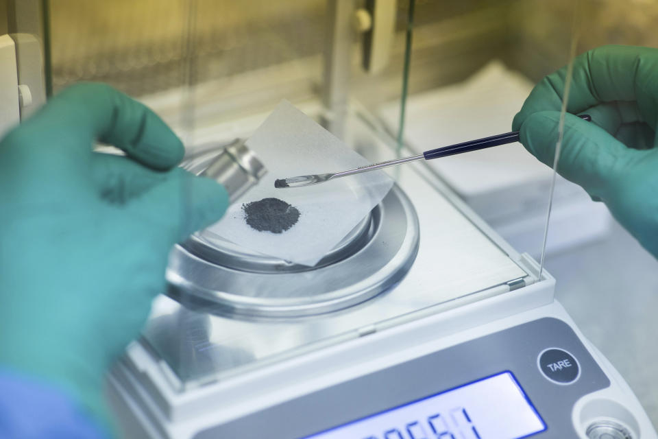 In this 2021 photo provided by the University of Florida, Institute of Food and Agricultural Sciences, Rob Ferl weighs lunar soil at a laboratory in Gainesville, Fla. The soil samples had been sealed in vials since the time of the Apollo 11, 12 and 17 missions to the moon, five decades ago. For the first time, scientists have used lunar soil collected by long-ago moonwalkers to grow plants, with results promising enough that NASA and others already are envisioning hothouses on the moon for the next generation of lunar explorers. (Tyler Jones/UF/IFAS via AP)