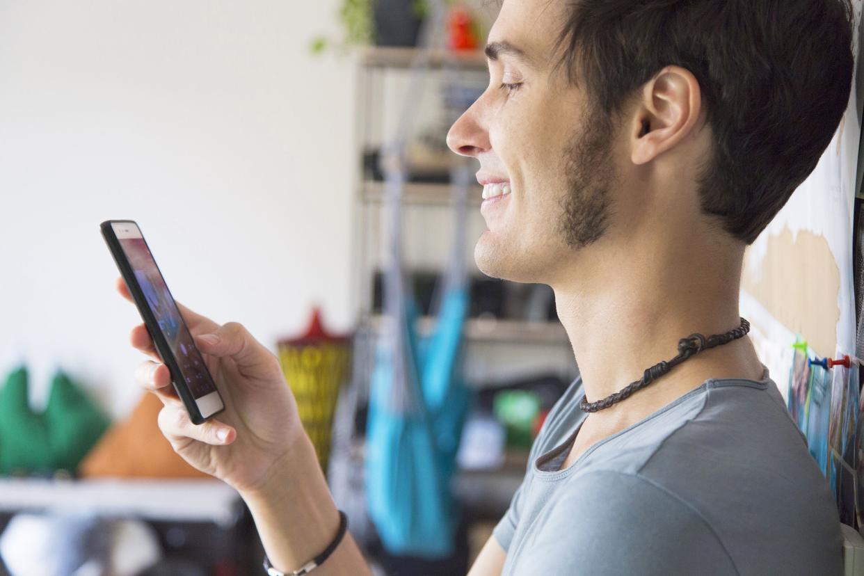 young man using smartphone at home